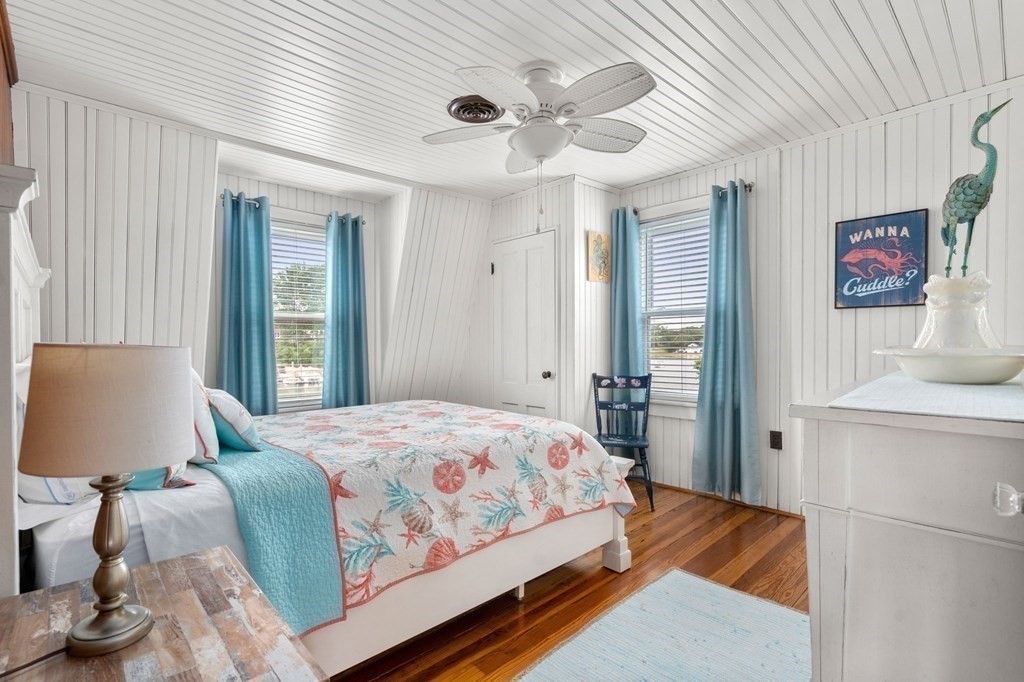 7 North Water Street Wareham, MA 02558 - Photo 22 of 39 a bedroom with a bed and a lamp on dresser with wooden floor