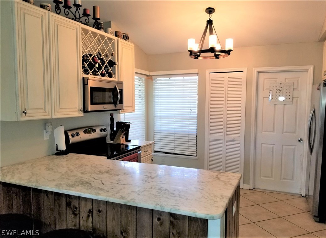 8201 Sandpiper Road Fort Myers, FL 33967 - Photo 4 of 11 a kitchen with a table chairs and refrigerator