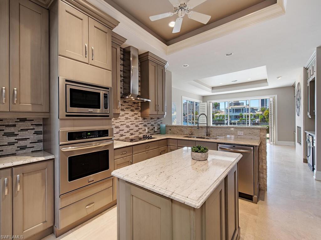 4459 Crayton Road Naples, FL 34103 - Photo 8 of 19 a kitchen with stainless steel appliances kitchen island granite countertop a stove and a sink