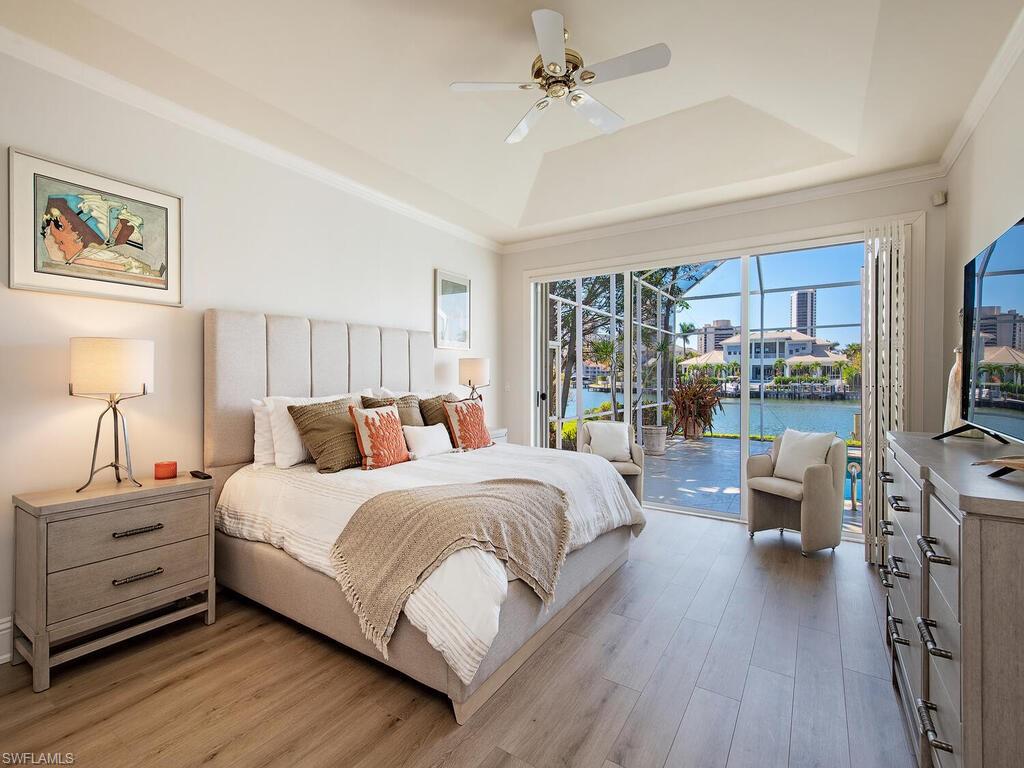 4459 Crayton Road Naples, FL 34103 - Photo 9 of 19 a bedroom with a large bed and a chandelier