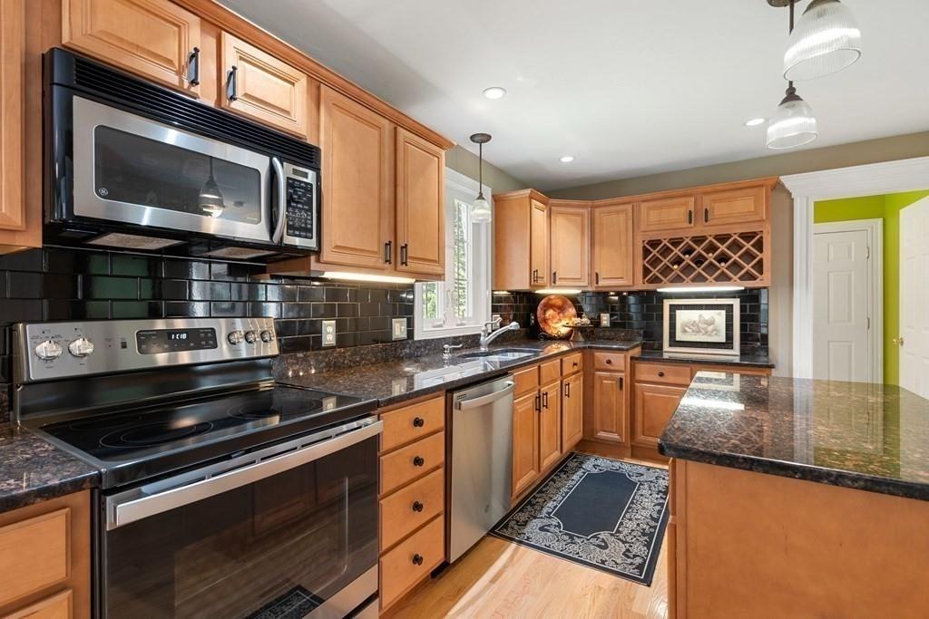 253 Walker Road Sturbridge, MA 01566 - Photo 7 of 31 a kitchen with stainless steel appliances granite countertop a stove a sink and a microwave