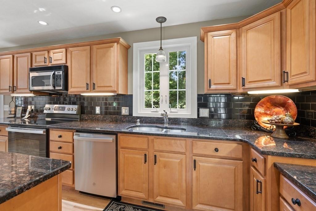253 Walker Road Sturbridge, MA 01566 - Photo 8 of 31 a kitchen with granite countertop a stove a sink and dishwasher wooden cabinets with granite countertops