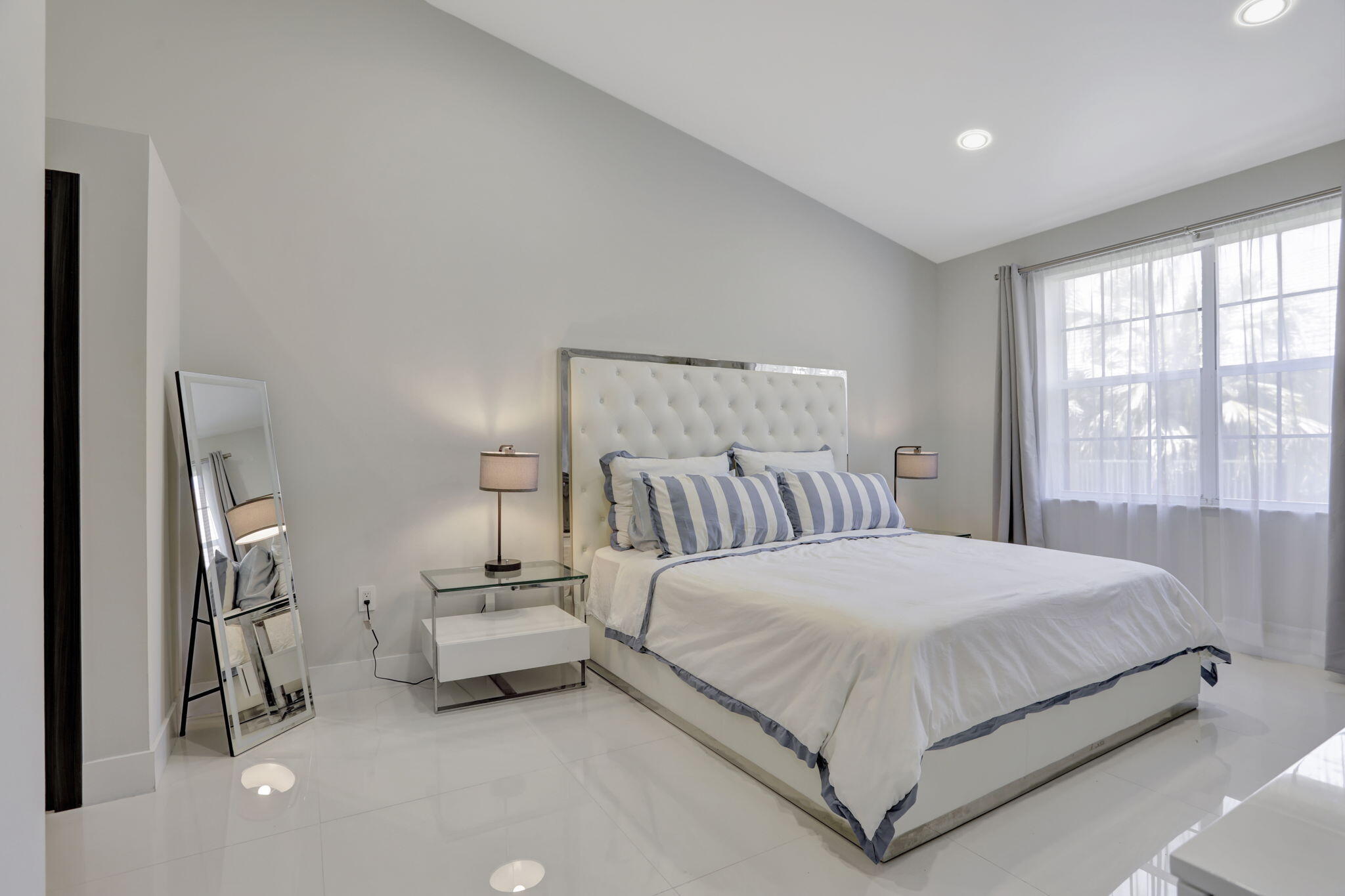 6584 Villa Sonrisa Drive, Unit 1122 Boca Raton, FL 33433 - Photo 19 of 22 a bedroom with a bed and a large window