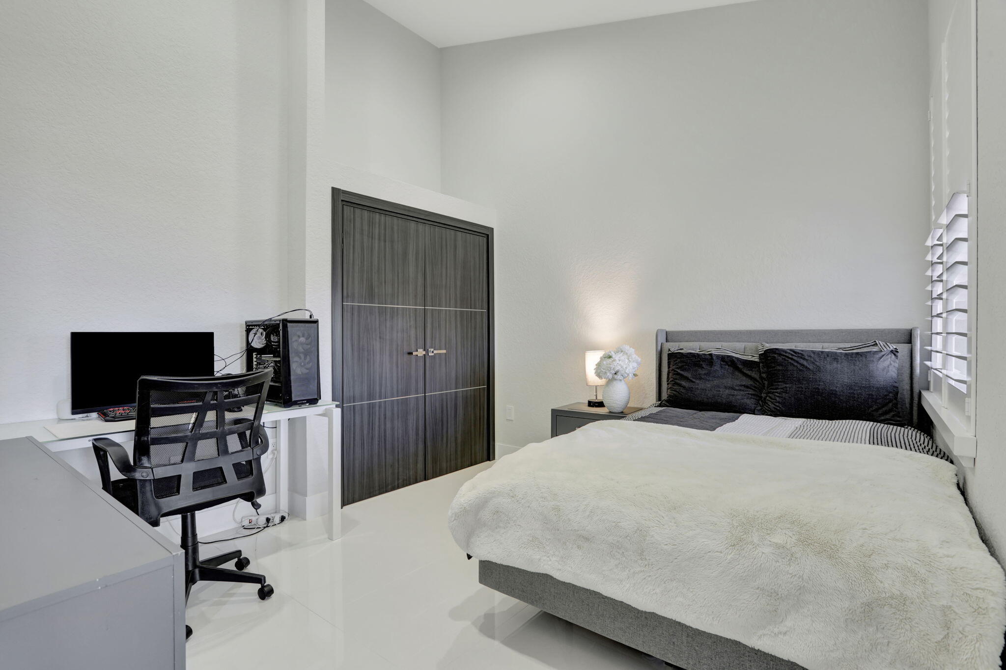 6584 Villa Sonrisa Drive, Unit 1122 Boca Raton, FL 33433 - Photo 5 of 22 a bedroom with a bed a chair and a flat screen tv