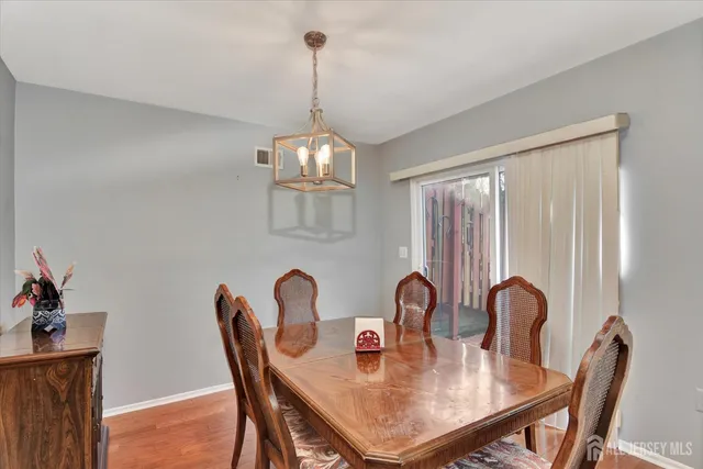 a view of a dining room with furniture a chandelier and wooden floor