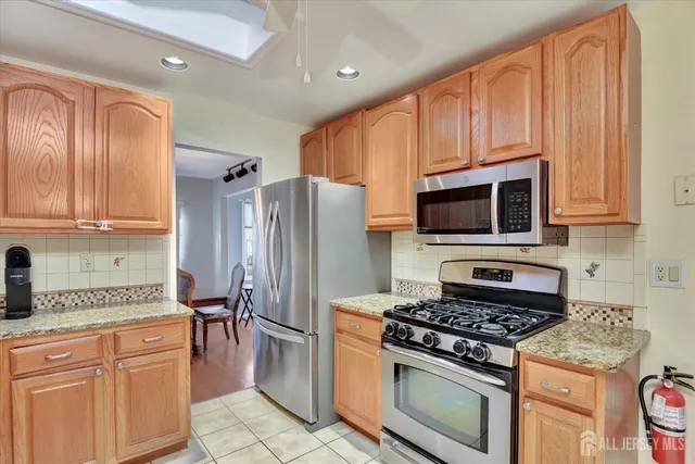 a kitchen with stainless steel appliances granite countertop a stove a refrigerator and a microwave