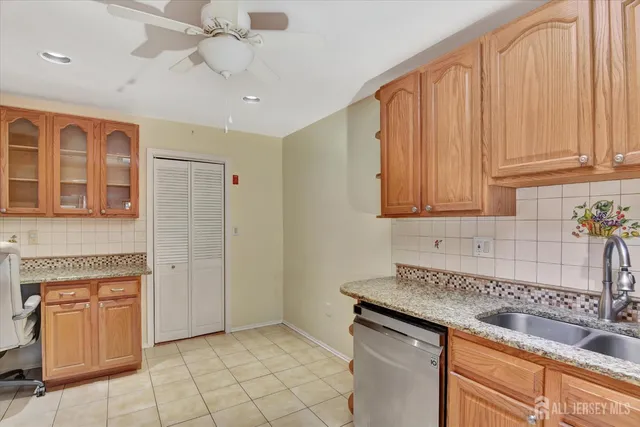 a kitchen with granite countertop a sink stainless steel appliances and cabinets