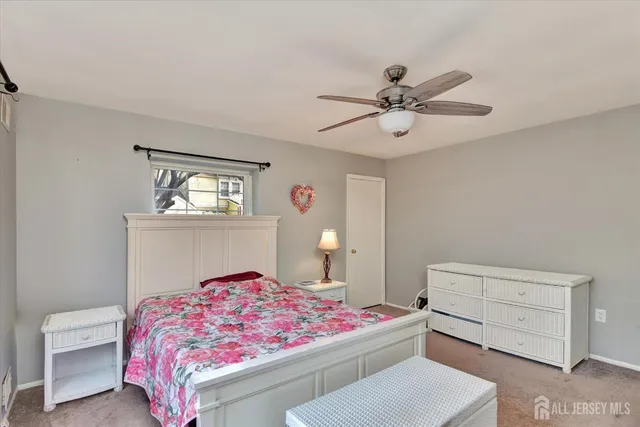 a bedroom with a bed and a chandelier fan