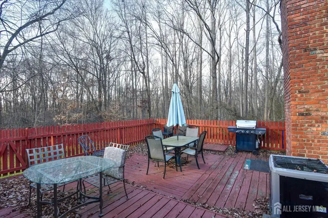 a view of a deck with furniture and trees around