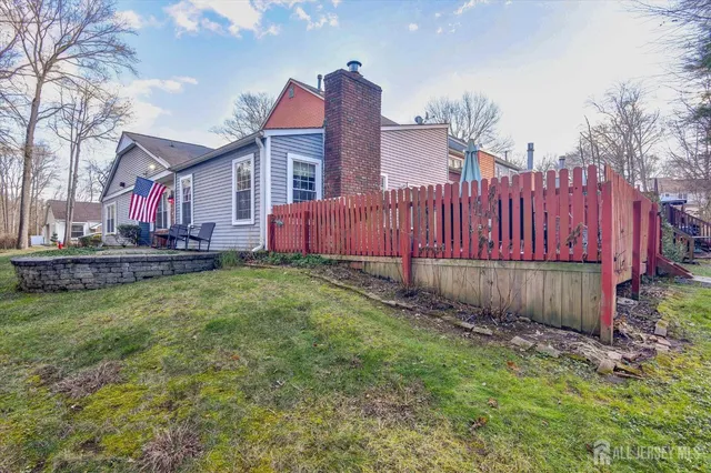 a view of a house with a yard and wooden fence