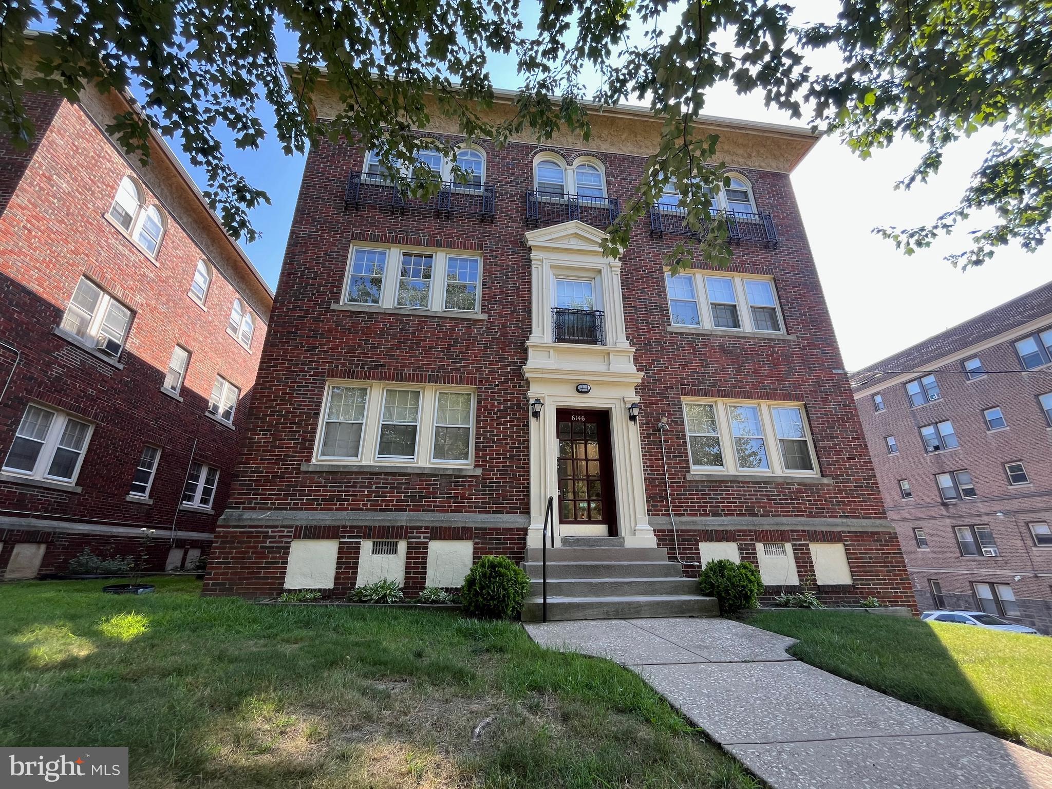 front view of a brick house with a yard