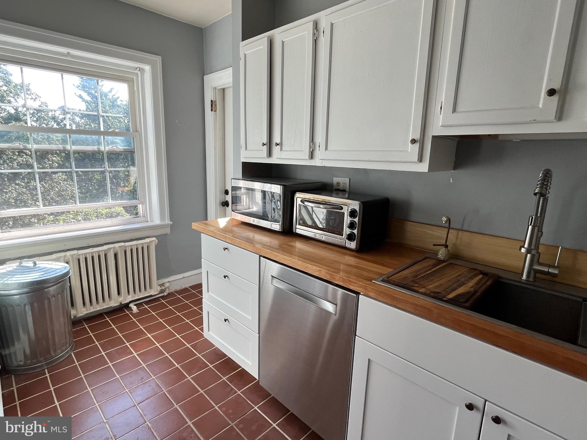 6146 Wayne Avenue, Unit 3 Philadelphia, PA 19144 - Photo 11 of 25 a kitchen with stainless steel appliances a white cabinets and a window