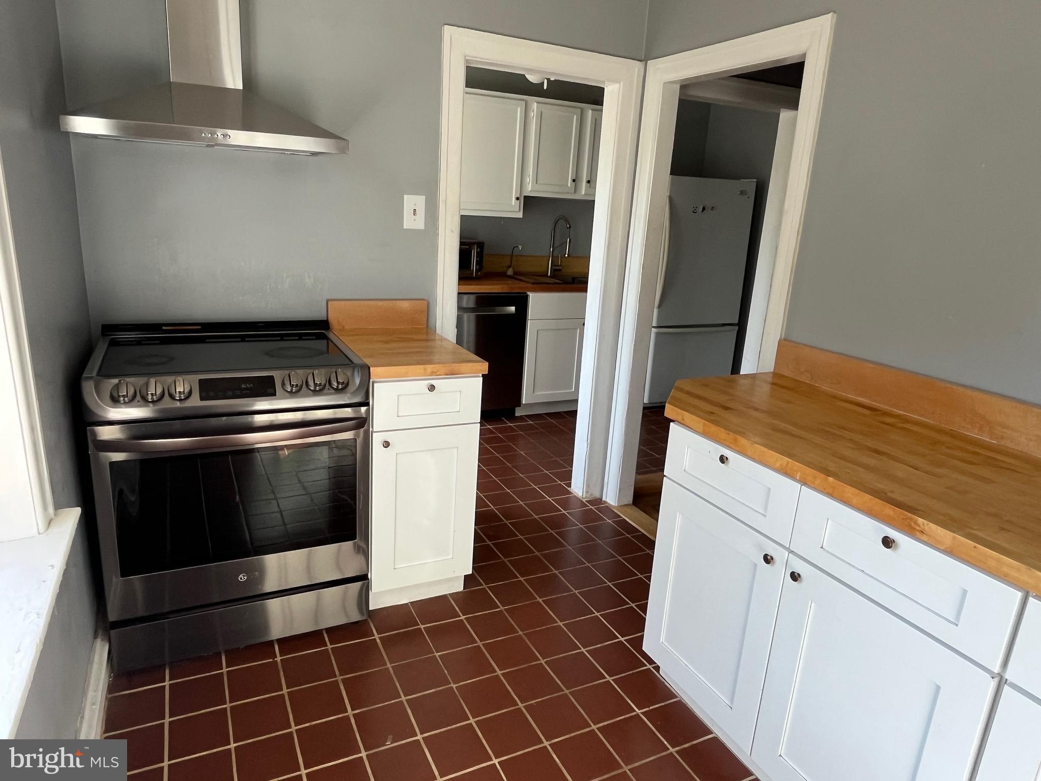6146 Wayne Avenue, Unit 3 Philadelphia, PA 19144 - Photo 13 of 25 a kitchen with granite countertop a stove and a refrigerator