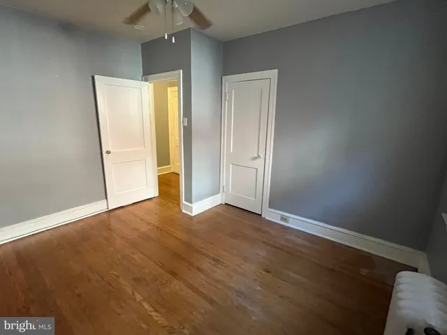 an empty room with wooden floor and cabinet