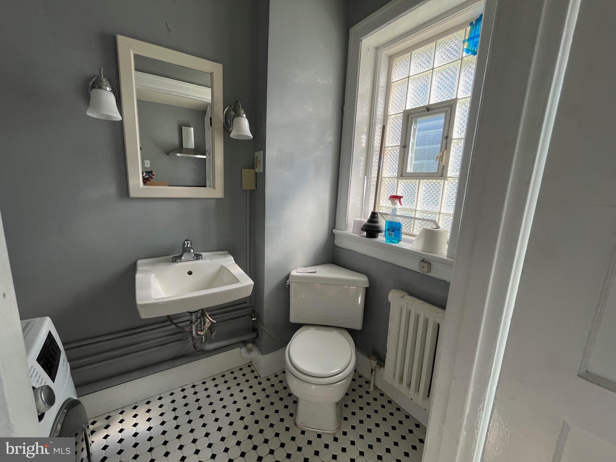 6146 Wayne Avenue, Unit 3 Philadelphia, PA 19144 - Photo 22 of 25 a bathroom with a toilet a sink and a mirror