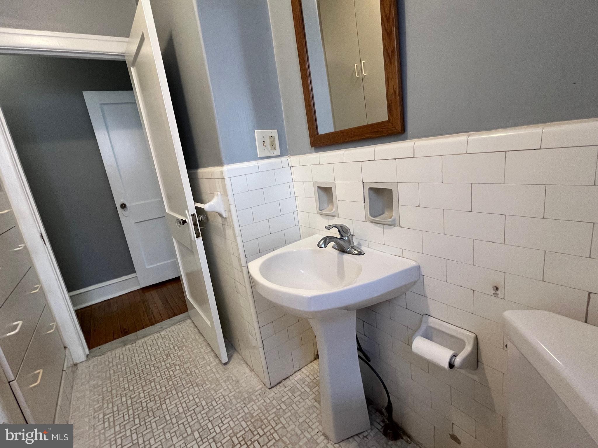 6146 Wayne Avenue, Unit 3 Philadelphia, PA 19144 - Photo 23 of 25 a bathroom with a sink a toilet and a mirror