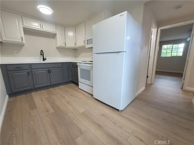 a kitchen with a refrigerator sink and cabinets
