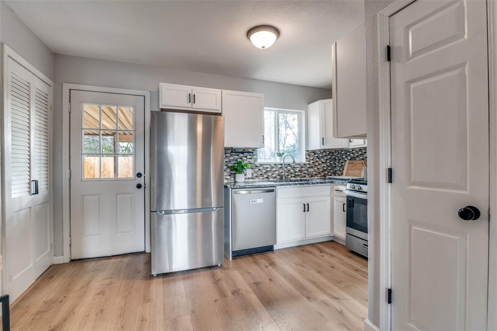 406 Freeman Street Mesquite, TX 75149 - Photo 7 of 22 a kitchen with a refrigerator wooden floor and window