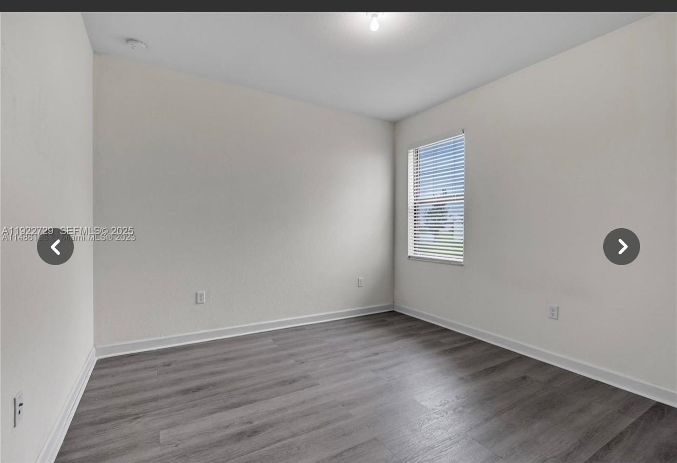 10091 West 35th Lane, Unit 10091 Hialeah, FL 33018 - Photo 11 of 32 a view of an empty room with wooden floor and a window