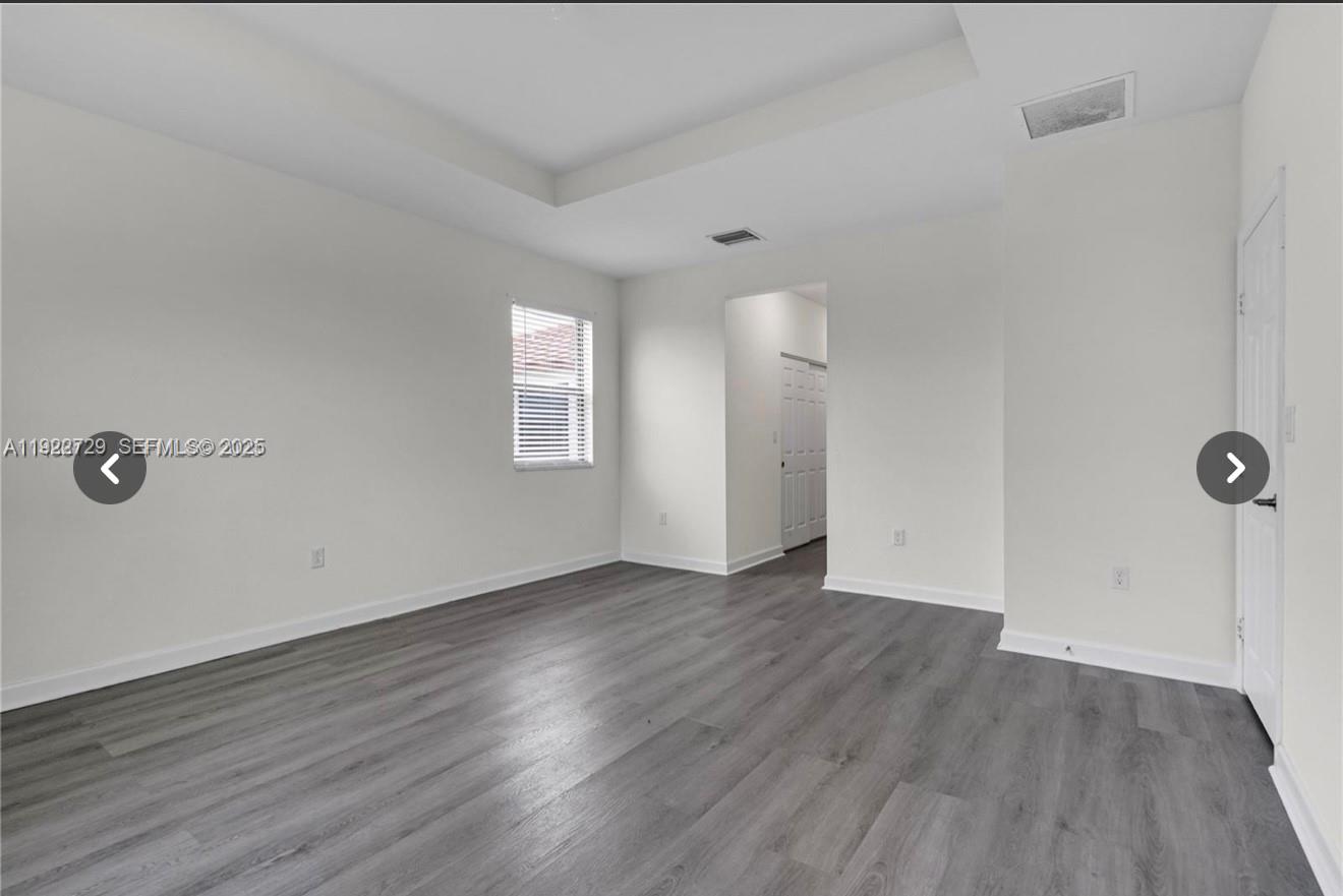 10091 West 35th Lane, Unit 10091 Hialeah, FL 33018 - Photo 15 of 32 an empty room with wooden floor and windows
