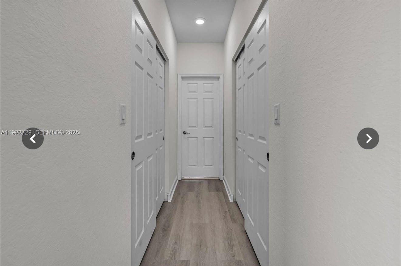 10091 West 35th Lane, Unit 10091 Hialeah, FL 33018 - Photo 16 of 32 a view of a hallway with wooden floor and a shower