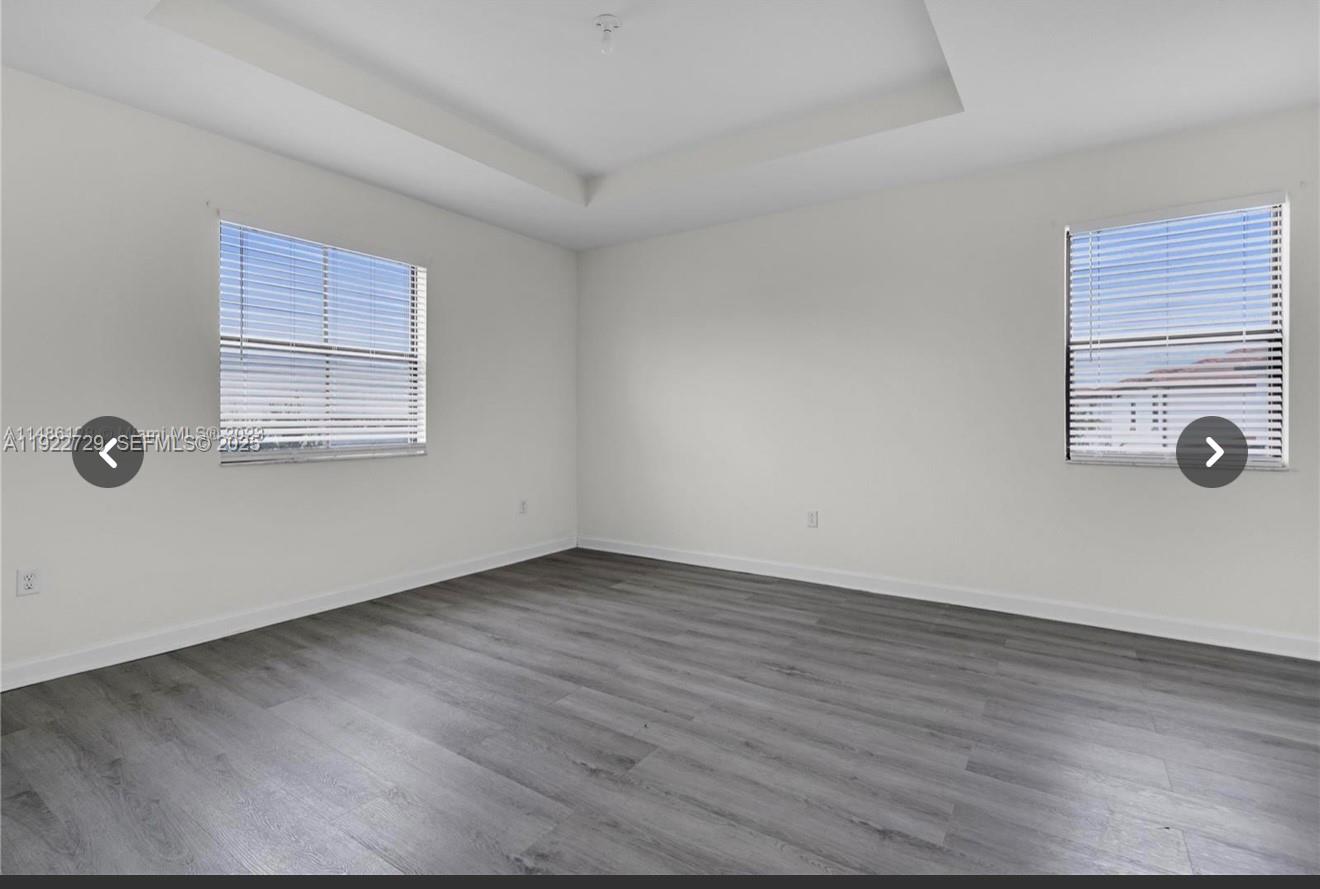 10091 West 35th Lane, Unit 10091 Hialeah, FL 33018 - Photo 21 of 32 an empty room with wooden floor and windows