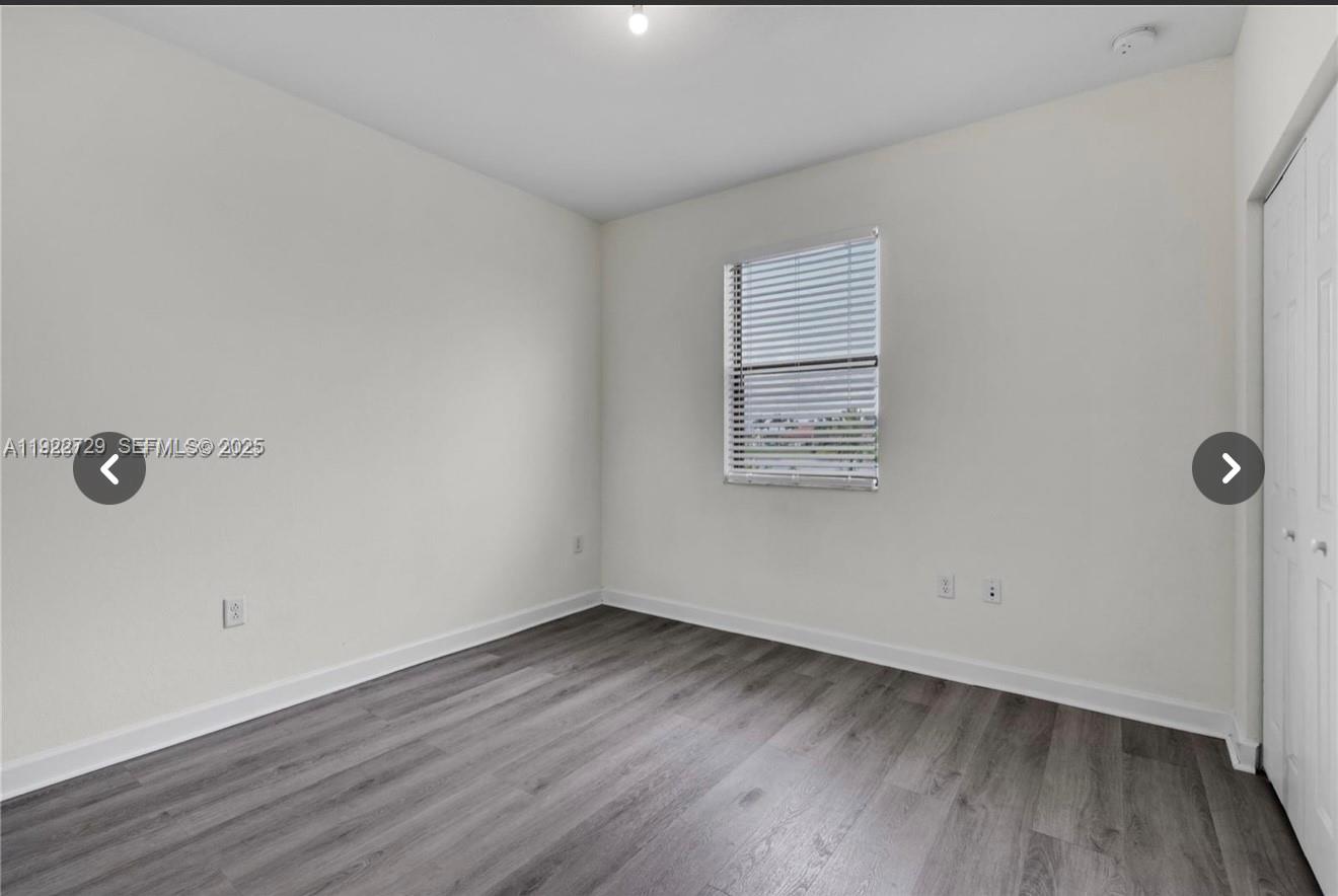 10091 West 35th Lane, Unit 10091 Hialeah, FL 33018 - Photo 22 of 32 an empty room with wooden floor and windows