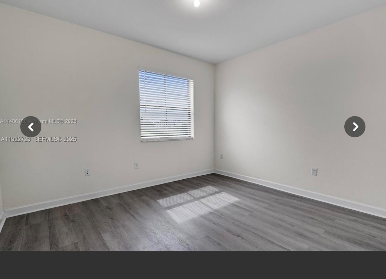 10091 West 35th Lane, Unit 10091 Hialeah, FL 33018 - Photo 24 of 32 an empty room with wooden floor and windows