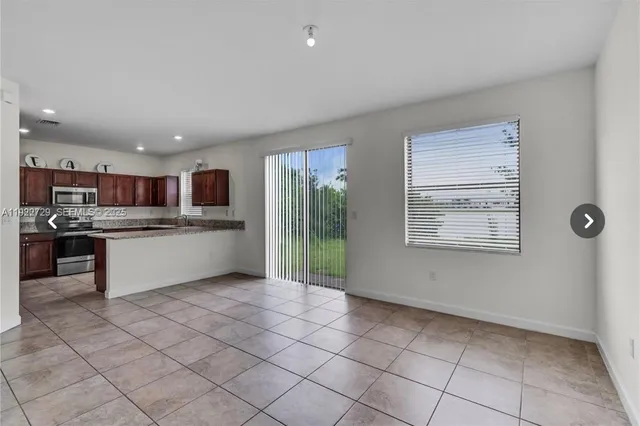 a open kitchen with kitchen island granite countertop a refrigerator oven a sink and dishwasher