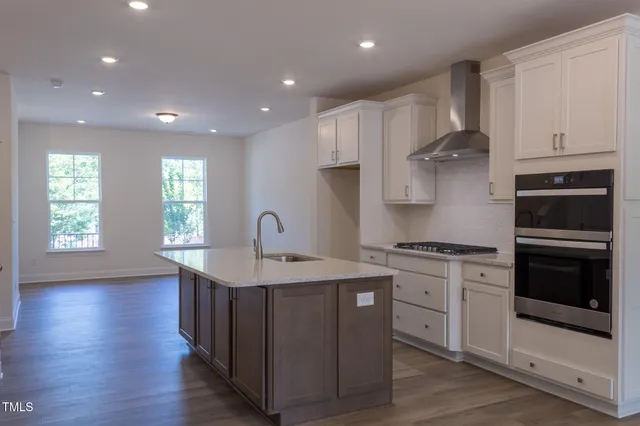 a kitchen with stainless steel appliances granite countertop a stove a sink and a refrigerator
