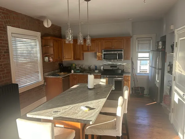 a kitchen with stainless steel appliances granite countertop a sink a stove and a refrigerator