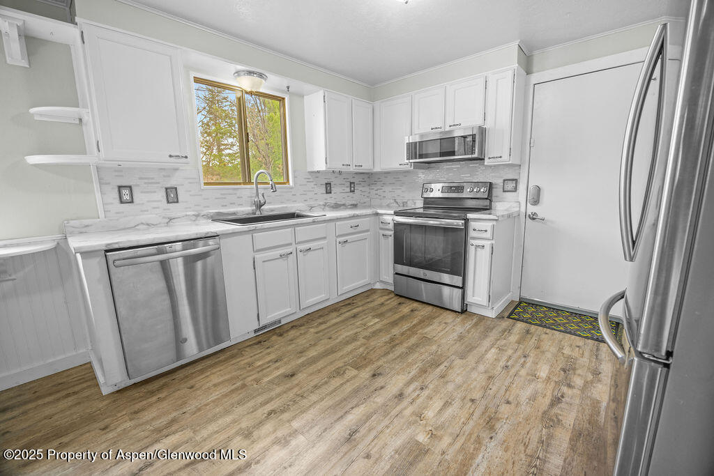 562 Rose Street Craig, CO 81625 - Photo 15 of 59 a kitchen with stainless steel appliances granite countertop a stove a sink and a refrigerator