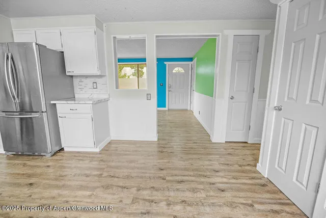 a kitchen with cabinets wooden floor and stainless steel appliances