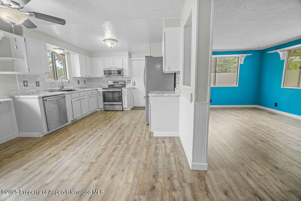 562 Rose Street Craig, CO 81625 - Photo 19 of 59 a kitchen with cabinets wooden floor and stainless steel appliances