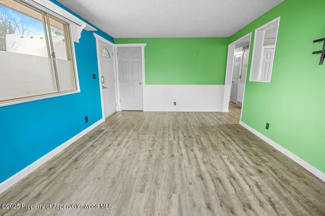 a view of an empty room with wooden floor