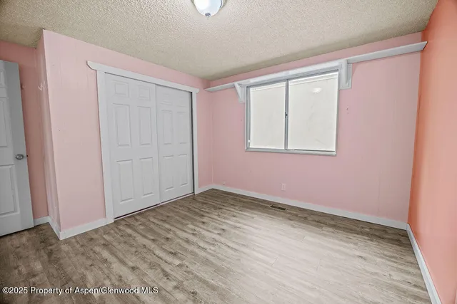 a view of a room with a ceiling fan and wooden floor
