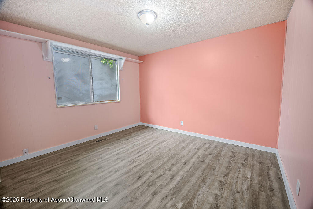 562 Rose Street Craig, CO 81625 - Photo 27 of 59 an empty room with wooden floor and windows