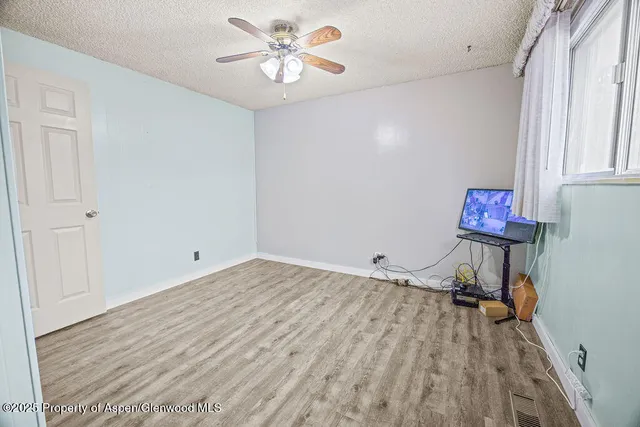 a view of a room with a window and wooden floor
