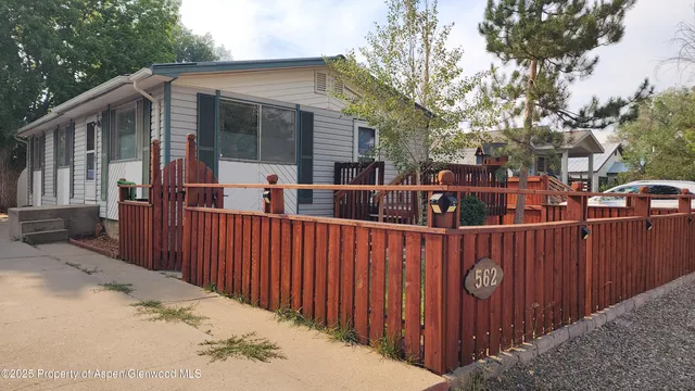 a view of a house with a wooden fence