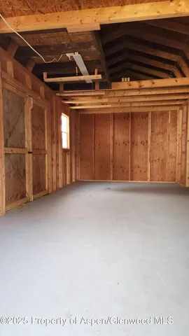a backyard of a house with wooden fence and large trees