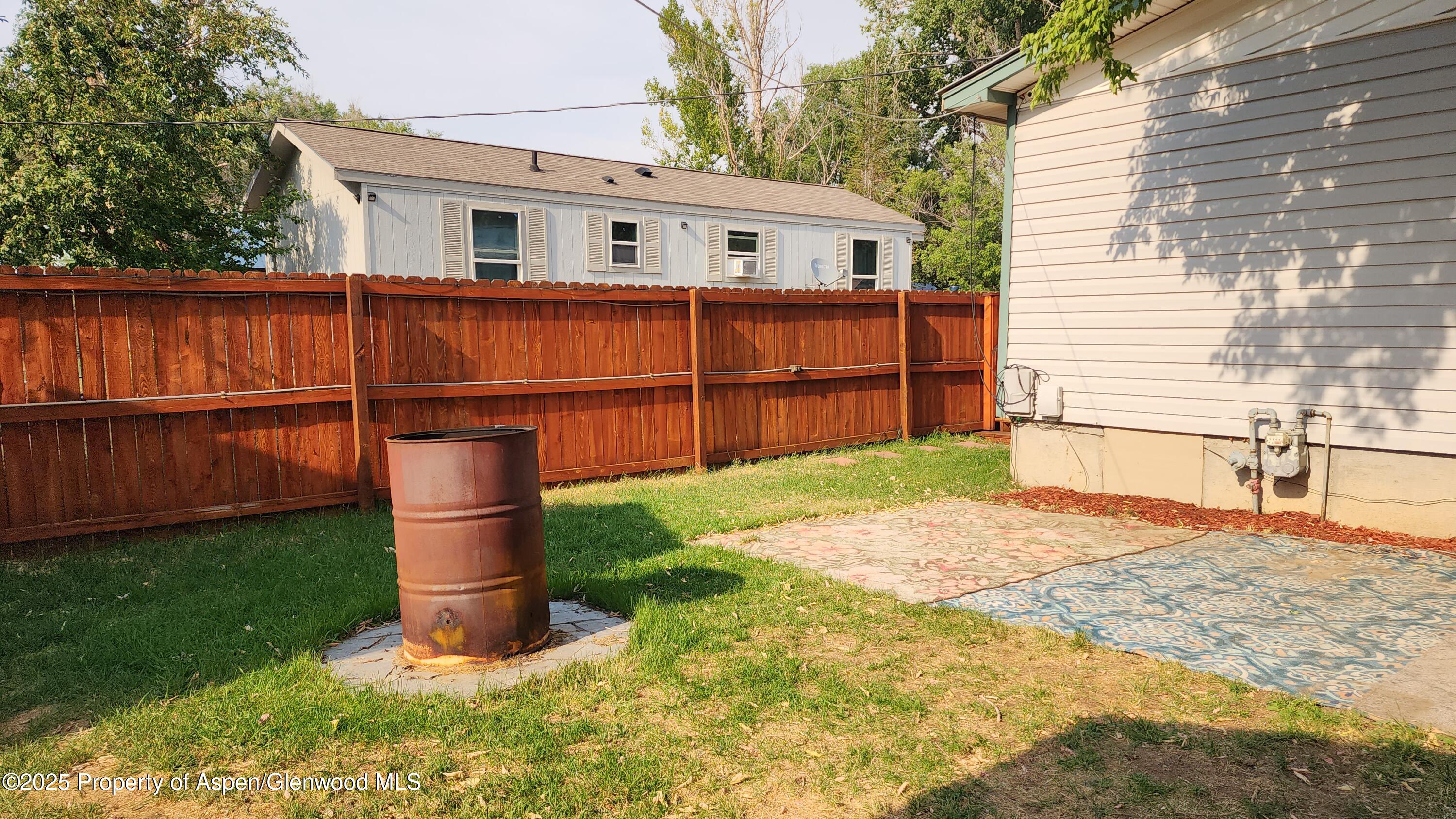 562 Rose Street Craig, CO 81625 - Photo 53 of 59 a backyard of a house with wooden fence and large trees