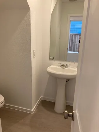 an empty room with wooden floor and a hallway