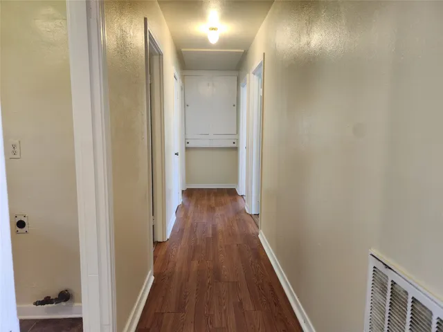 a view of a hallway with wooden floor