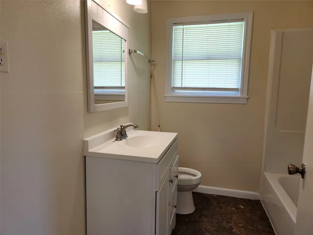 a bathroom with a sink toilet and window