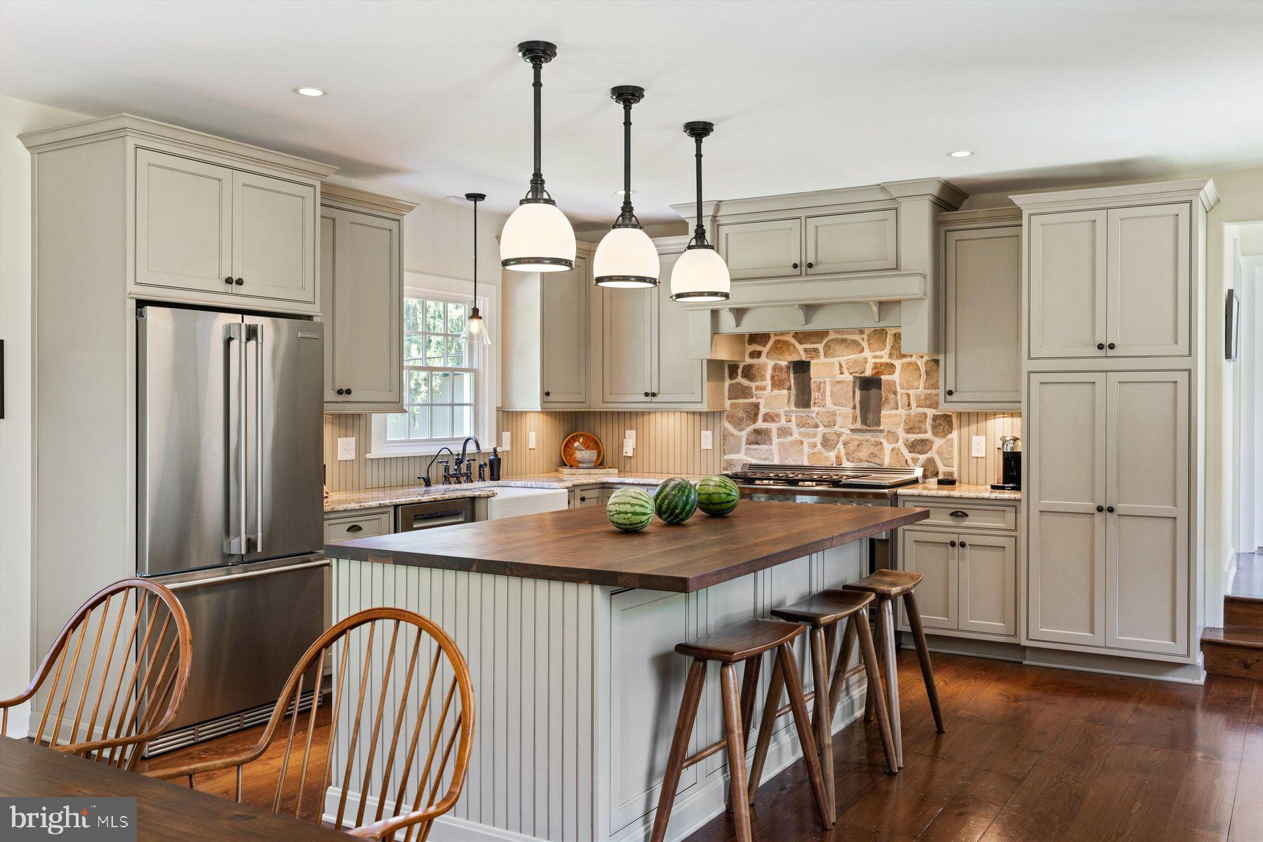 3087 Creamery Road New Hope, PA 18938 - Photo 18 of 68 a kitchen with stainless steel appliances granite countertop a kitchen island a stove a refrigerator a sink a dining table and chairs with wooden floor