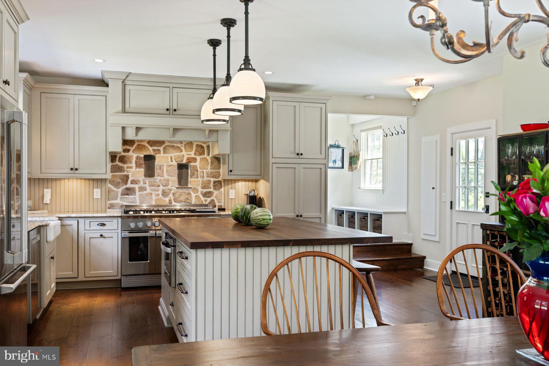 3087 Creamery Road New Hope, PA 18938 - Photo 19 of 68 a kitchen with stainless steel appliances granite countertop a stove a sink dishwasher a refrigerator and a dining table with wooden floor