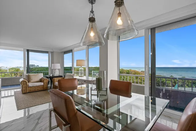 a very nice looking living room with a large window and dining table