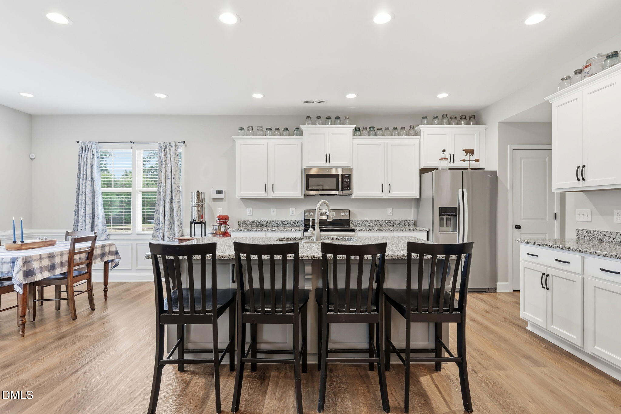 5098 Spring Hill Church Road Lillington, NC 27546 - Photo 10 of 36 a kitchen with stainless steel appliances kitchen island granite countertop a dining table chairs and a refrigerator
