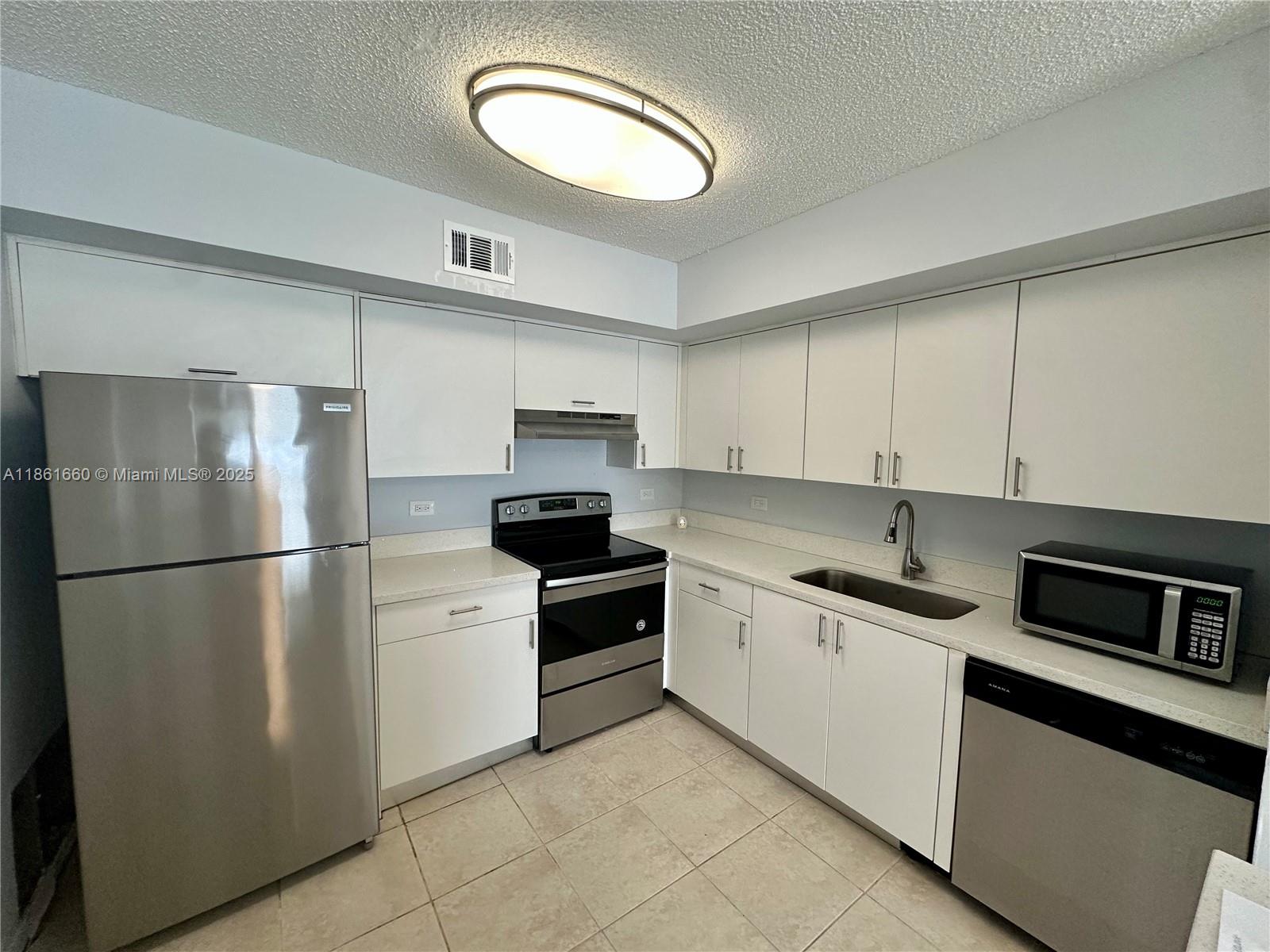 Playland Hollywood, FL 33021 - Photo 4 of 18 a kitchen with stainless steel appliances a refrigerator sink and cabinets