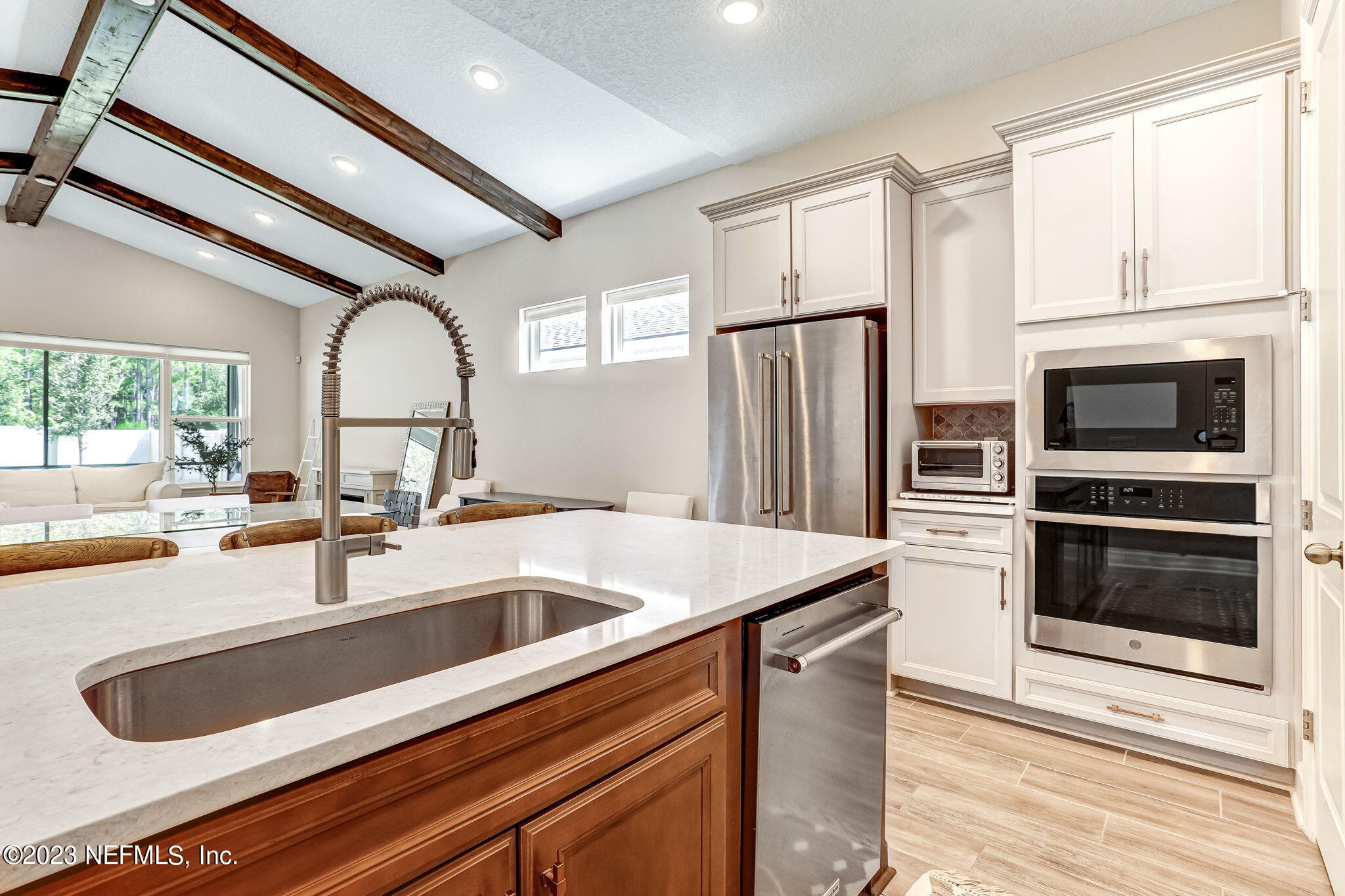 9863 Invention Lane Jacksonville, FL 32256 - Photo 18 of 56 a kitchen with stainless steel appliances a sink a stove and a refrigerator with wooden floor